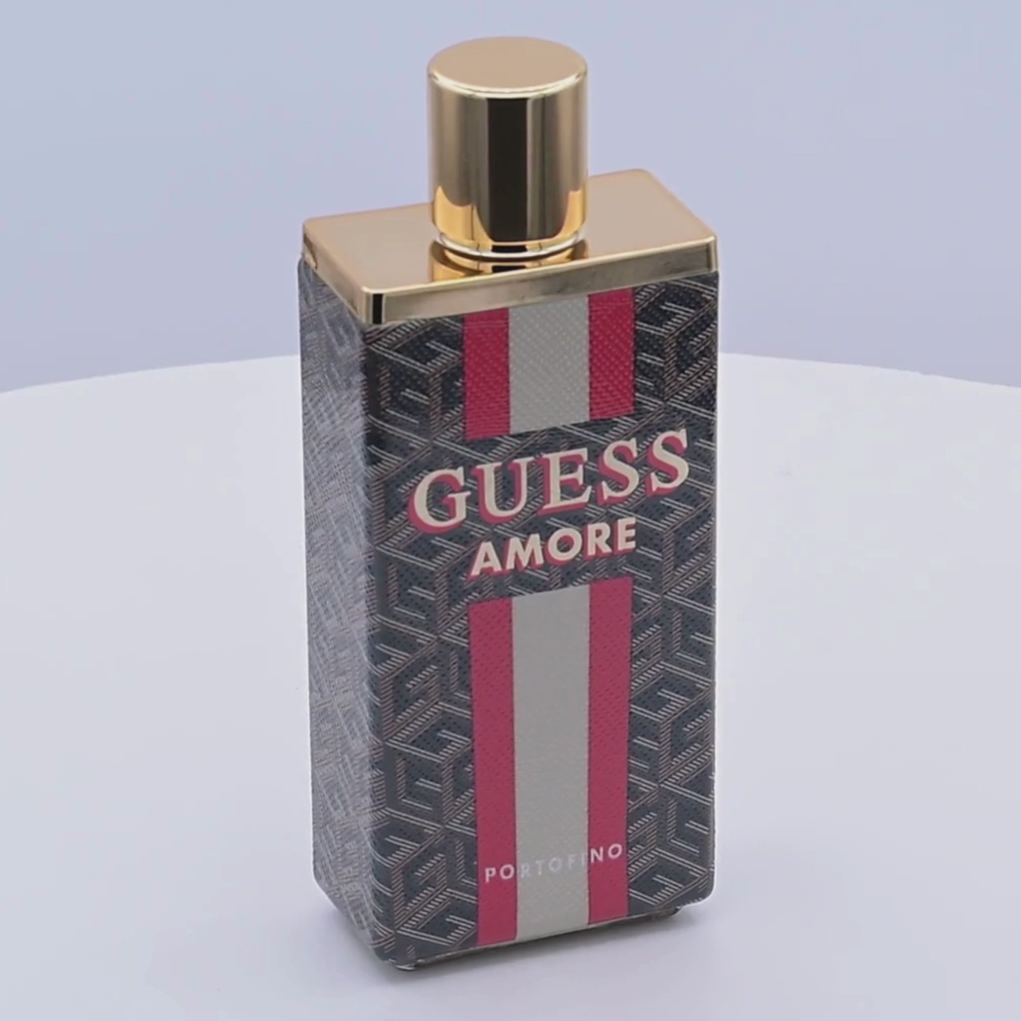 Guess Amore perfume bottle rotating on a white podium