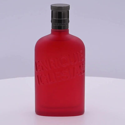 Red Enrique Iglesias Adrenaline perfume bottle rotating on a white podium