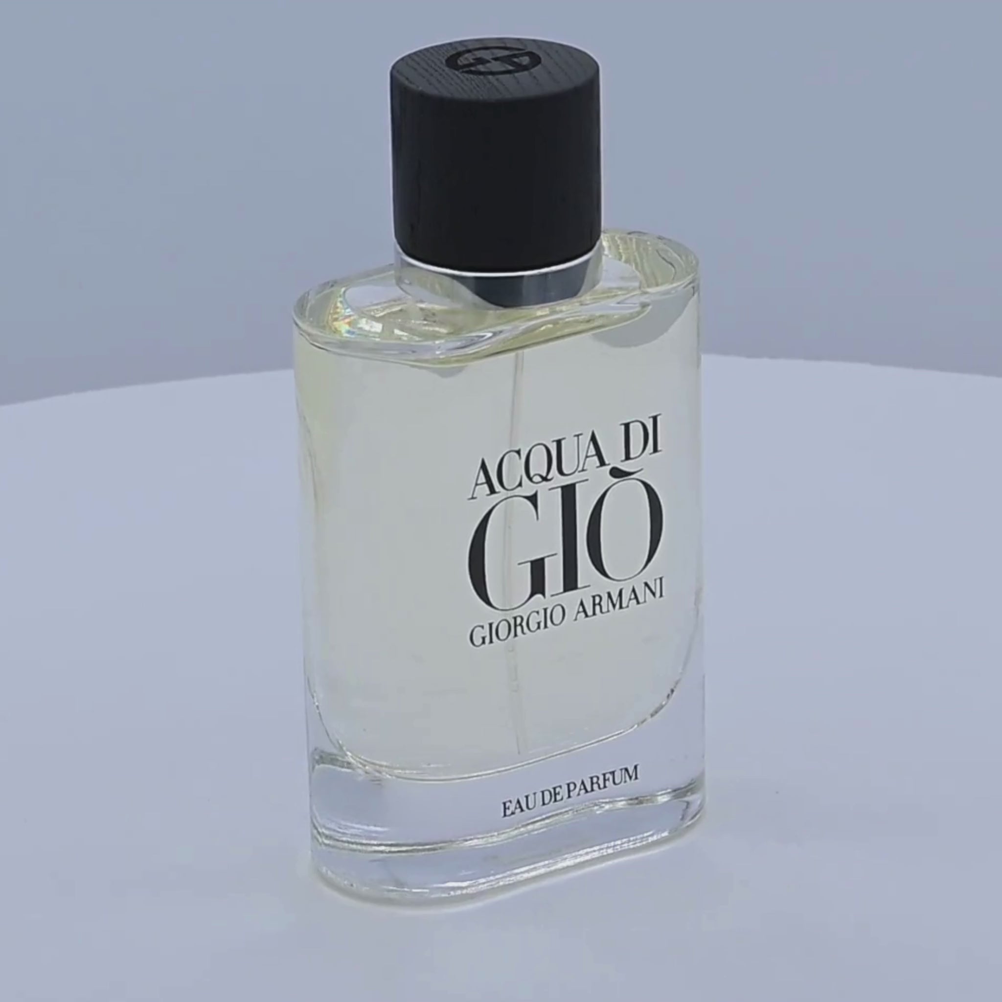 Acqua di Giò Eau de Parfum bottle rotating on a white podium