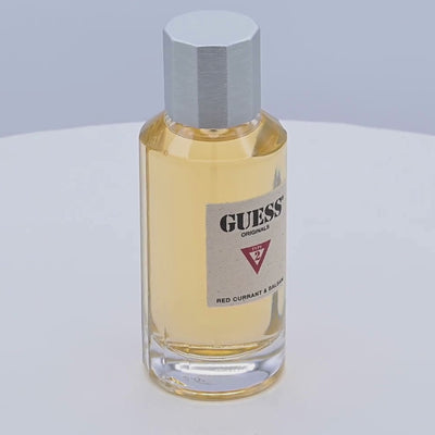 Guess perfume bottle rotating on a white podium