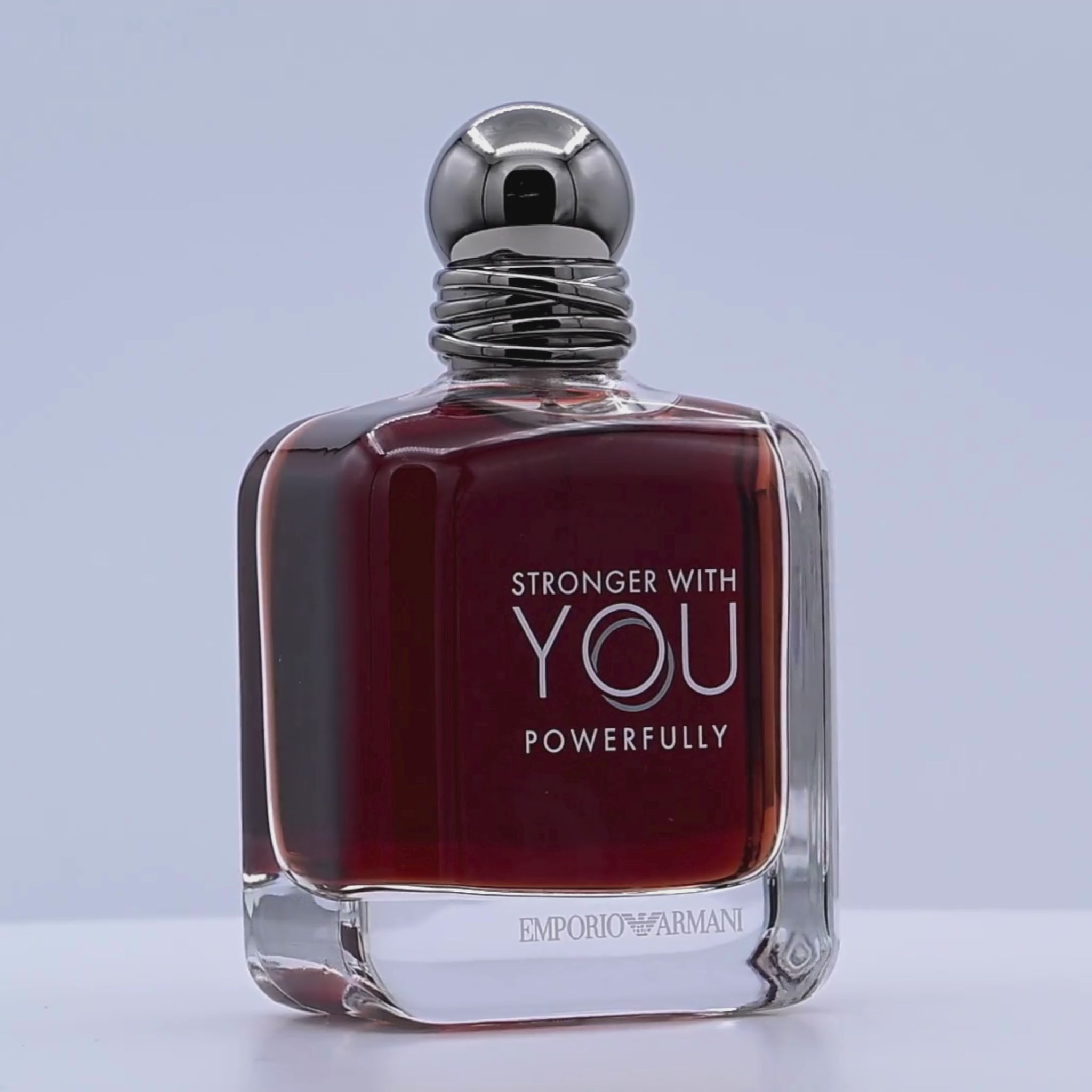 Emporio Armani perfume bottle rotating on a white podium