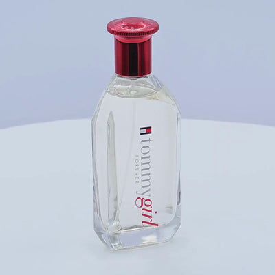 Tommy Hilfiger cologne bottle rotating on a white podium