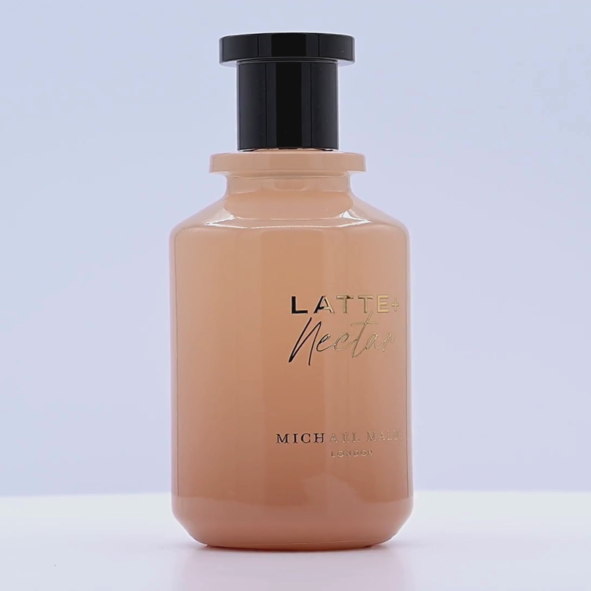 Bottle of Latte Nectar by Michael Maller rotating on a white podium