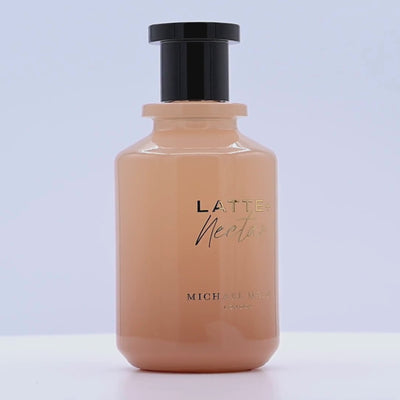 Bottle of Latte Nectar by Michael Maller rotating on a white podium