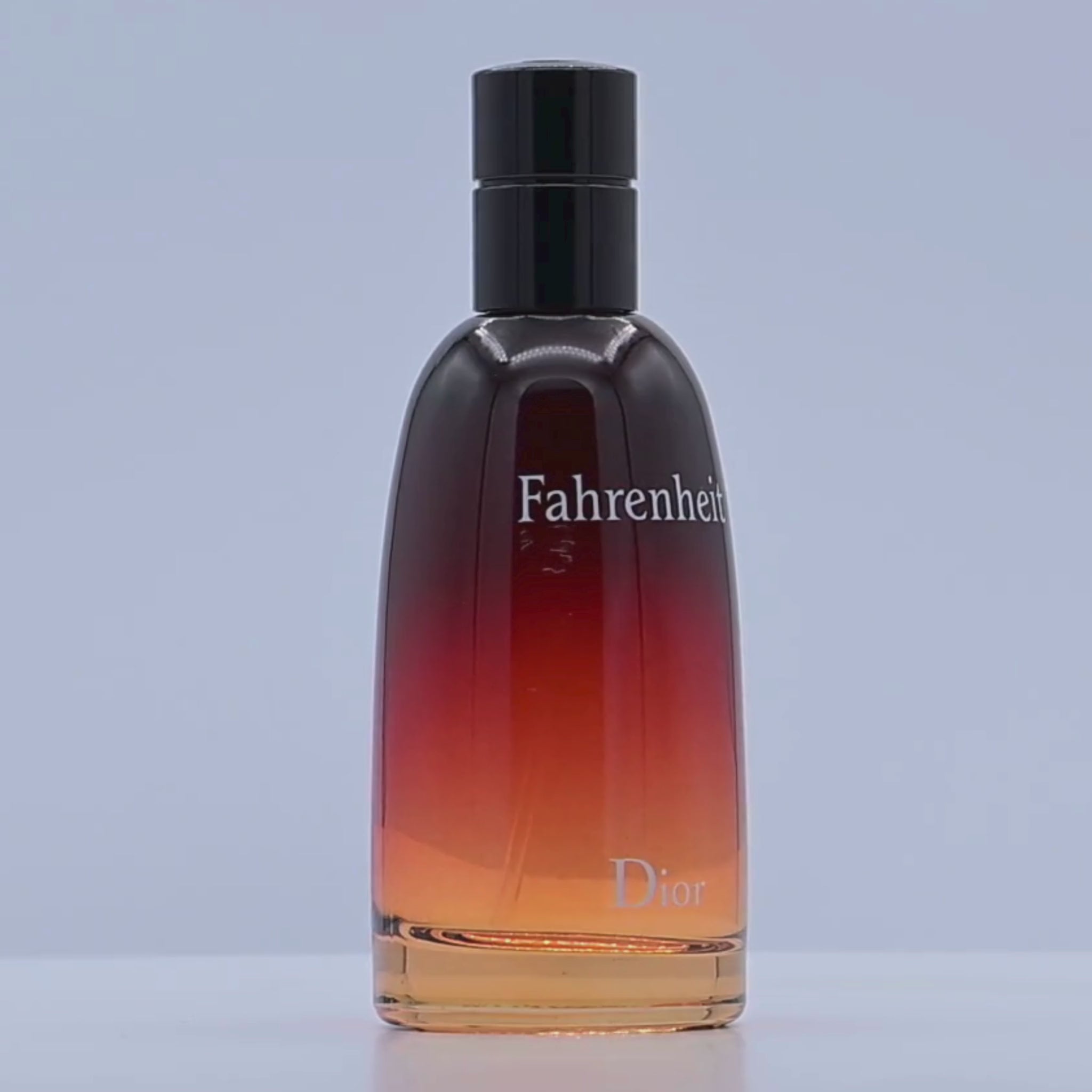 Dior Fahrenheit perfume bottle rotating on a white podium