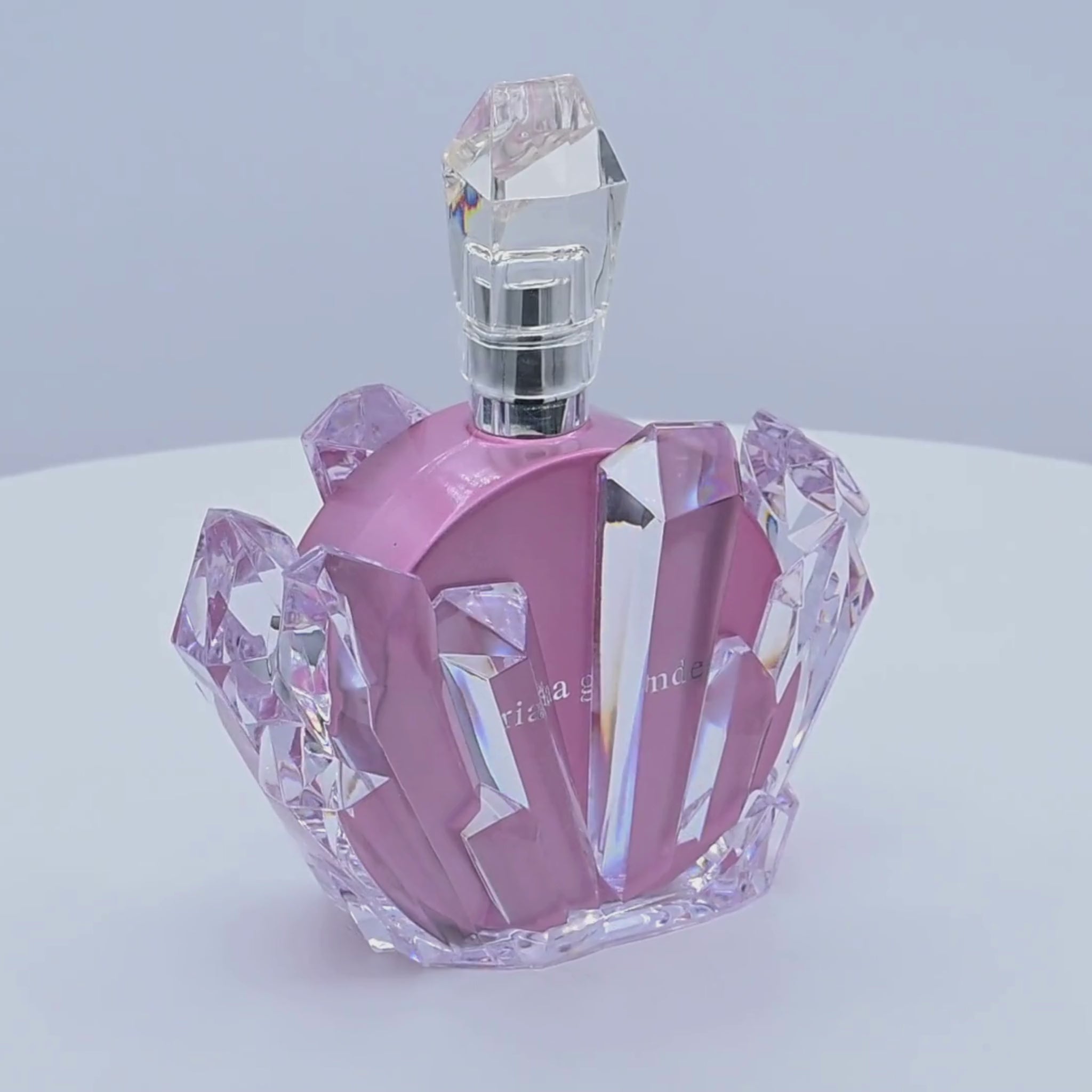Pink perfume bottle rotating on a white background 