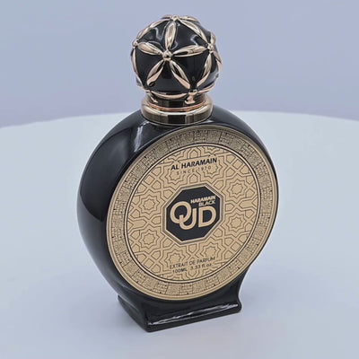 Black and gold Al Haramain perfume bottle rotating on a white podium