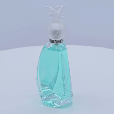 Anna Sui Secret Wish perfume bottle rotating on a white podium