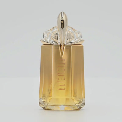 Mugler Alien perfume bottle rotating on a white podium
