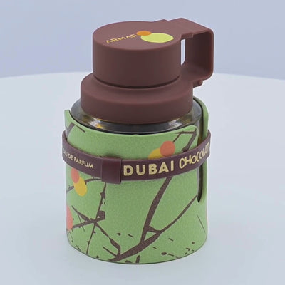 Odyssey Dubai Chocolat perfume bottle rotating on a white podium