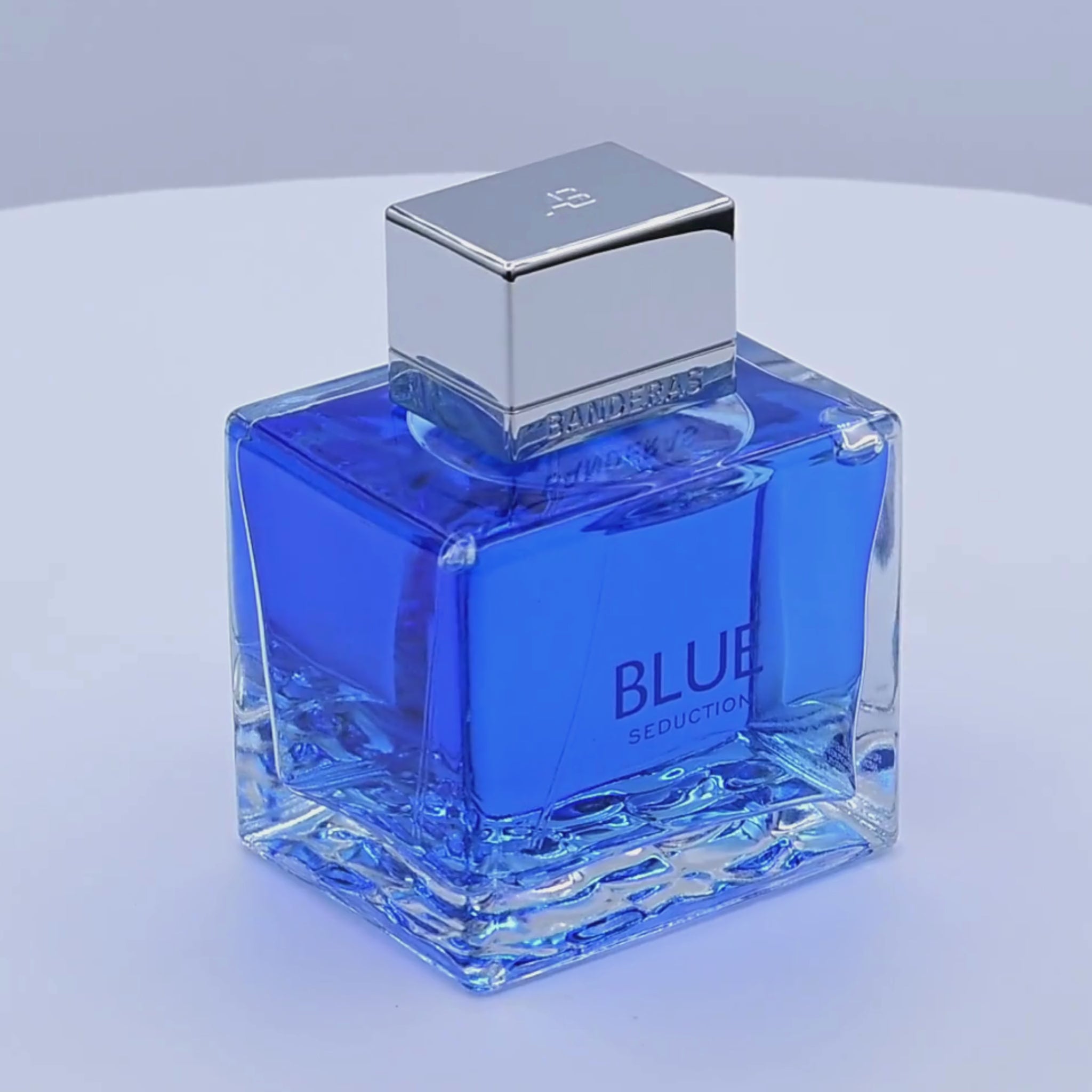 Banderas Blue Seduction perfume bottle rotating on a white podium