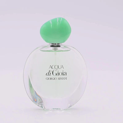 Giorgio Armani Acqua di Gioia perfume bottle rotating on a white podium

