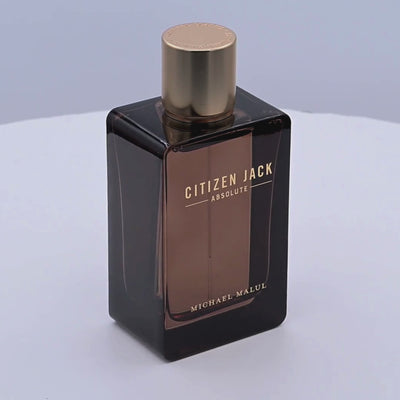 Perfume bottle labeled 'Citizen Jack Absolute' by Michael Malul rotating on a white podium