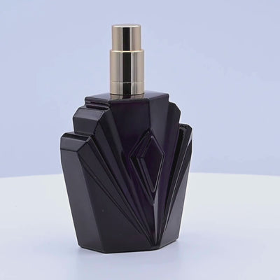 Black perfume bottle with gold cap rotating on a white podium
