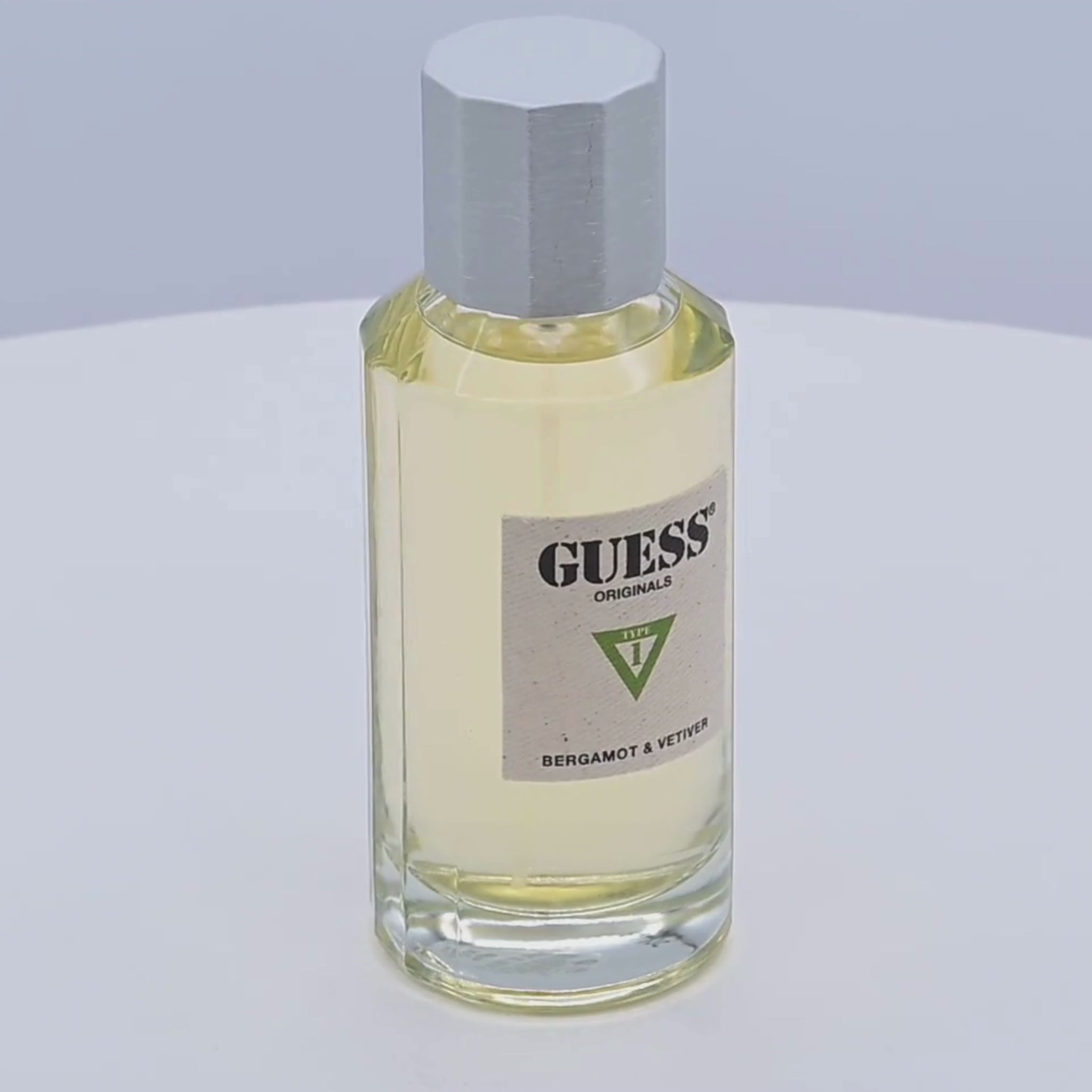Guess perfume bottle rotating on a white podium