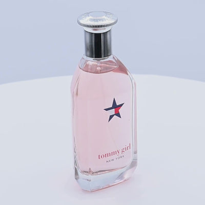 Tommy Girl perfume bottle rotating on a white podium