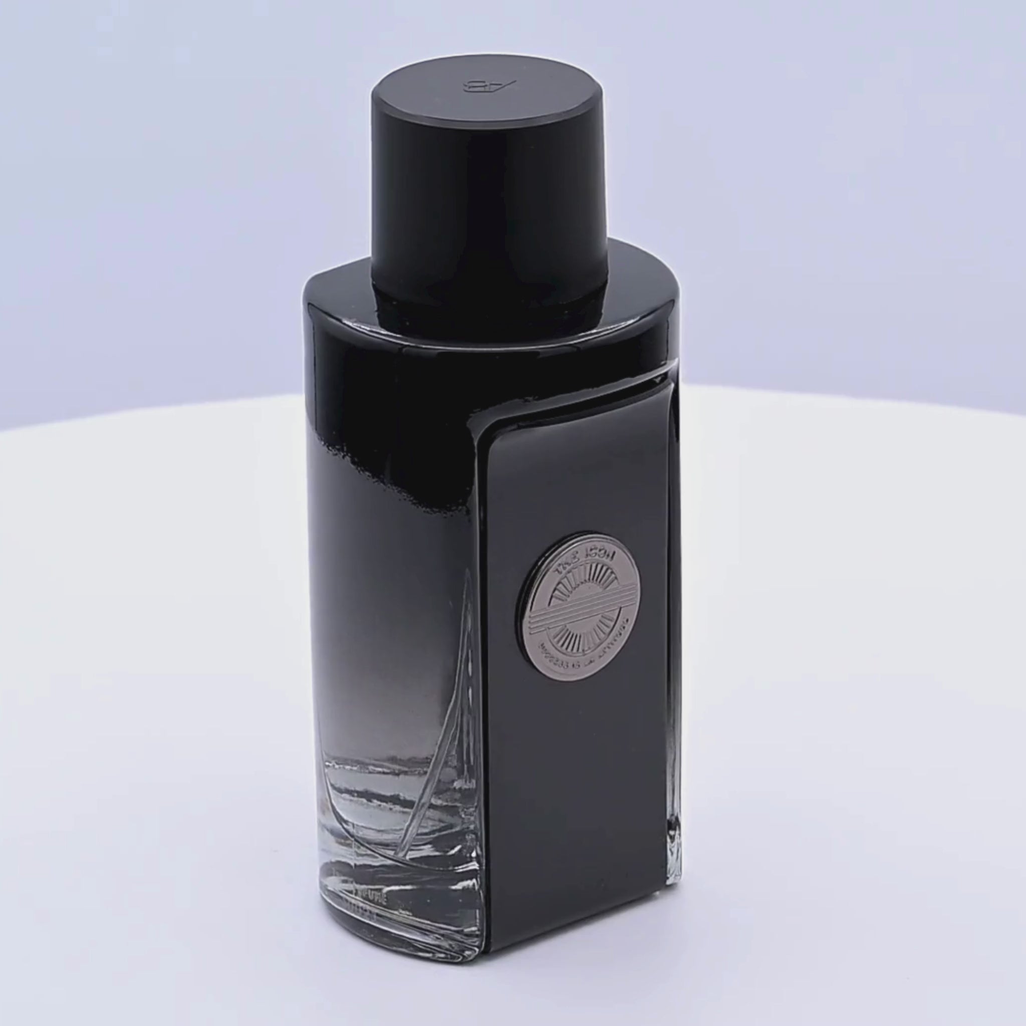 Black perfume bottle rotating on a white podium