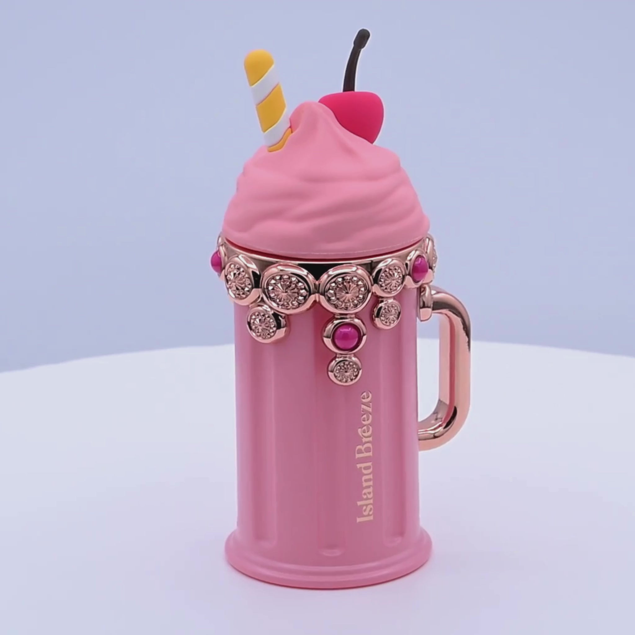 Pink dessert-shaped perfume bottle rotating on a white podium