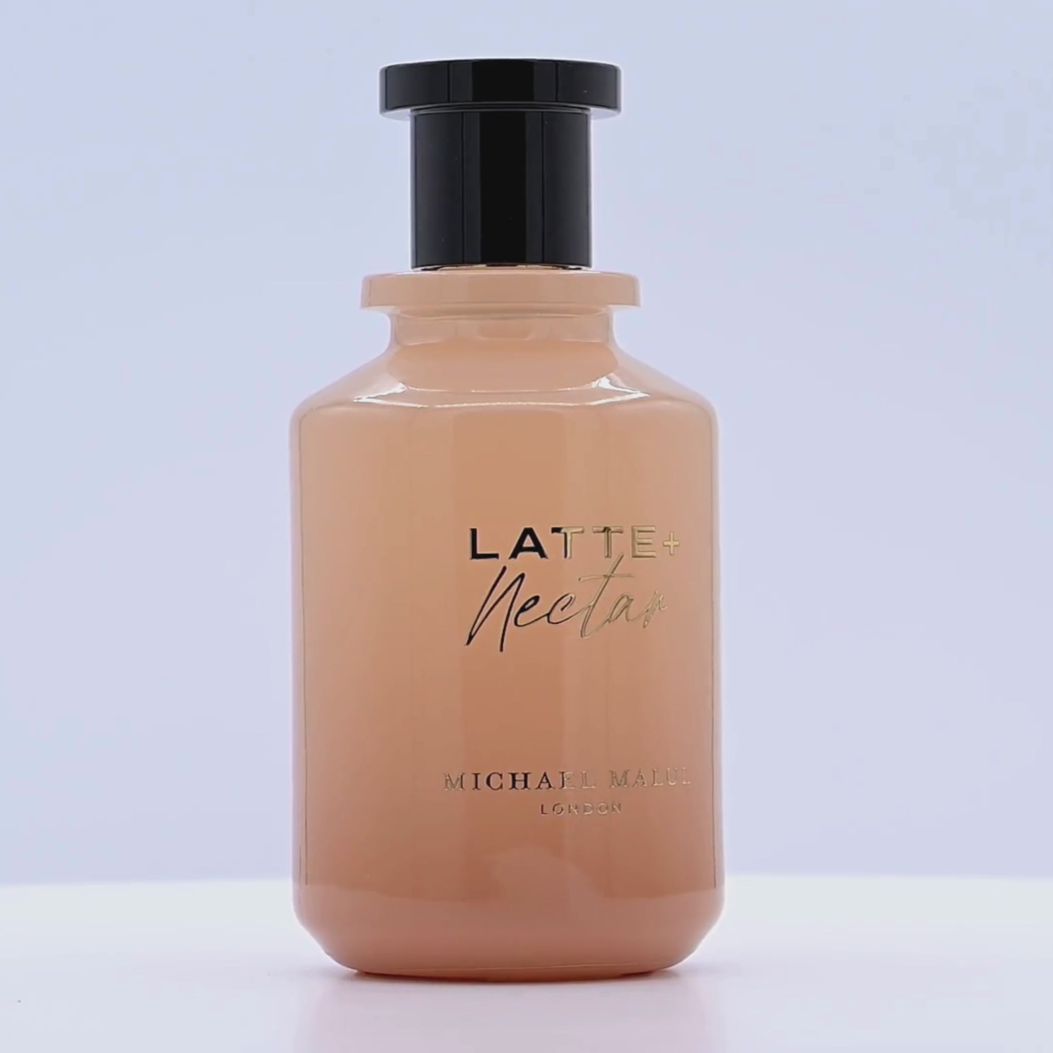 Bottle of Latte Nectar by Michael Malul rotating on a white podium