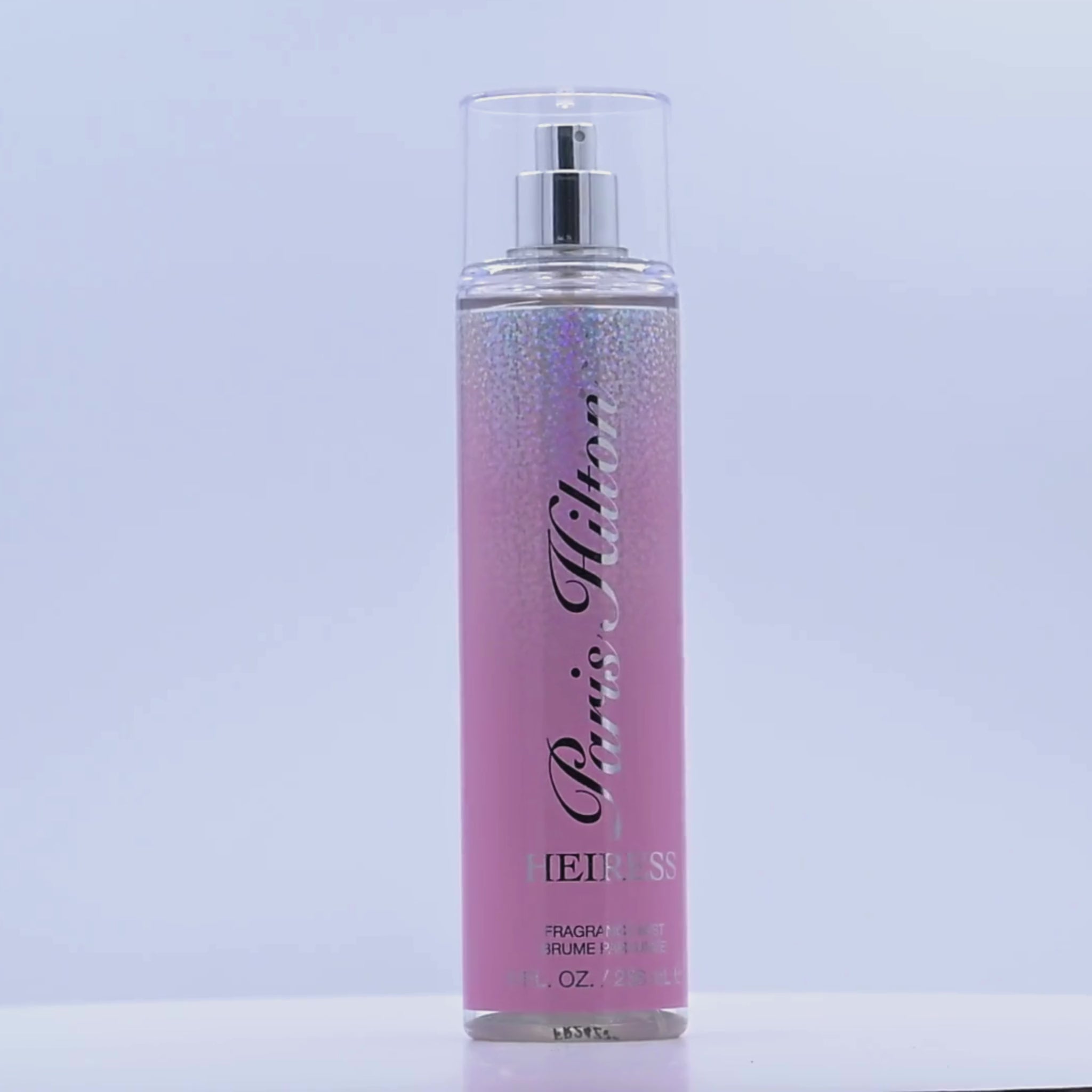 Pink Paris Hilton Heiress fragrance mist bottle rotating on a white podium