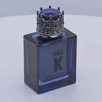 Dolce & Gabbana K perfume bottle rotating on a white podium