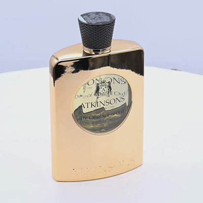 Gold Atkinsons perfume bottle rotating on a white podium