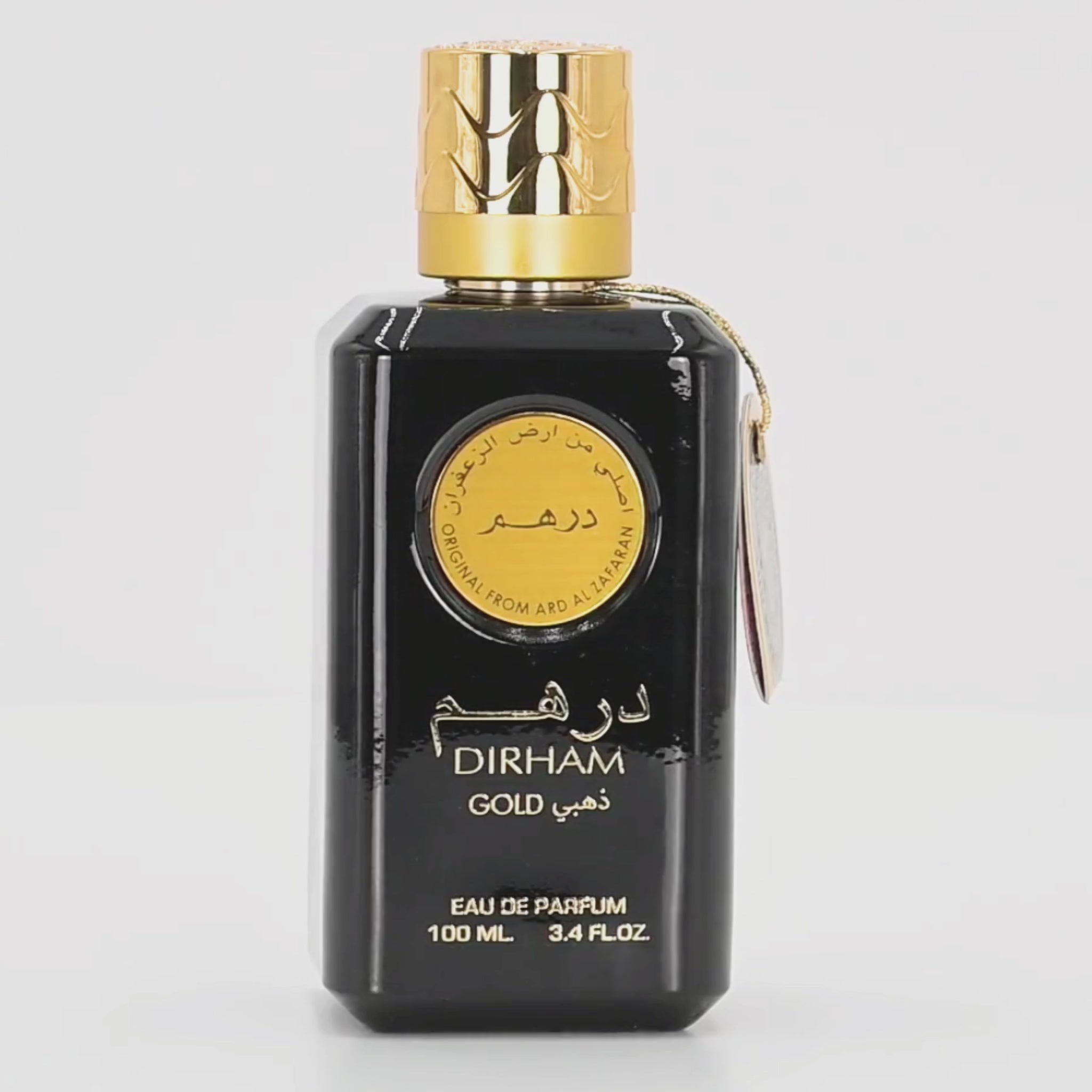 Dirham Gold perfume bottle rotating on a white podium
