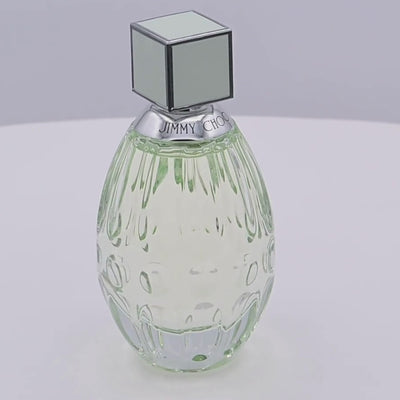 Jimmy Choo floral perfume bottle rotating on a white podium