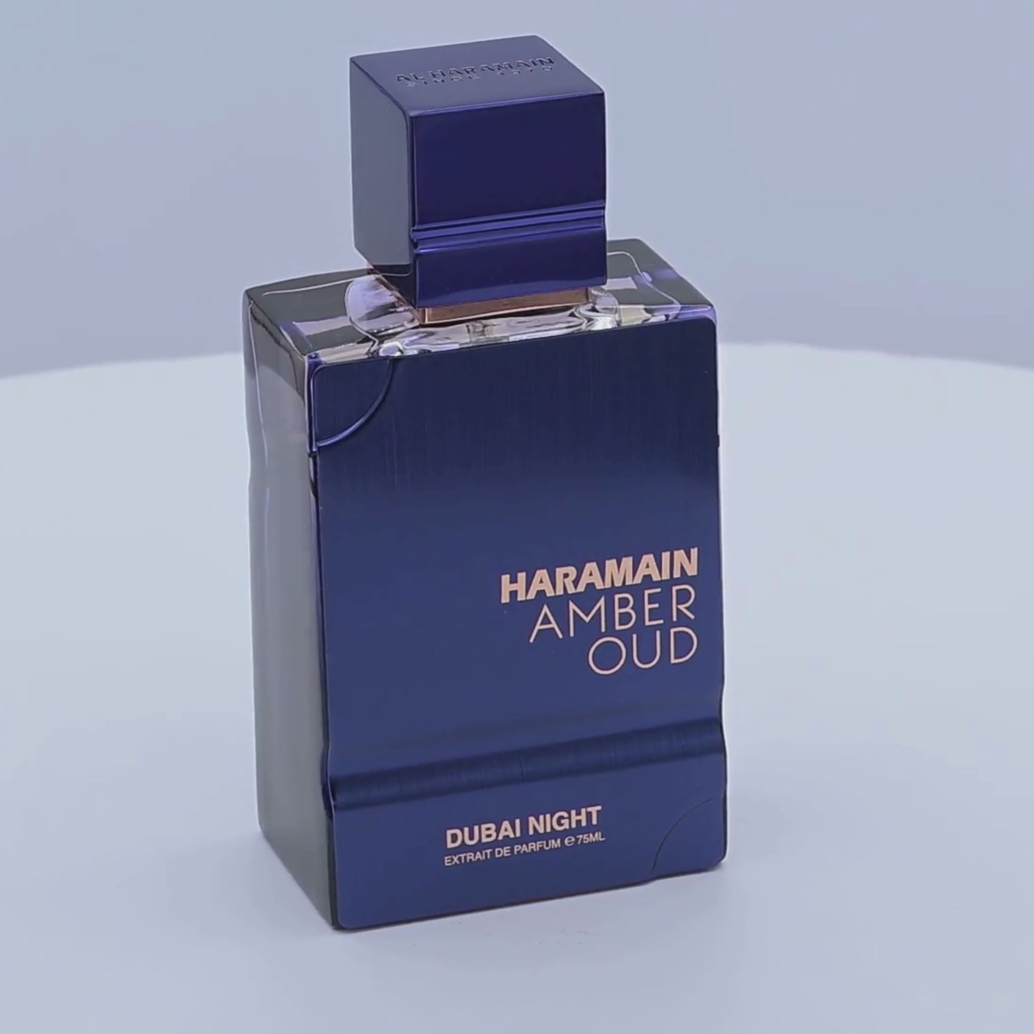 Haramain Amber Oud perfume bottle rotating on a white podium