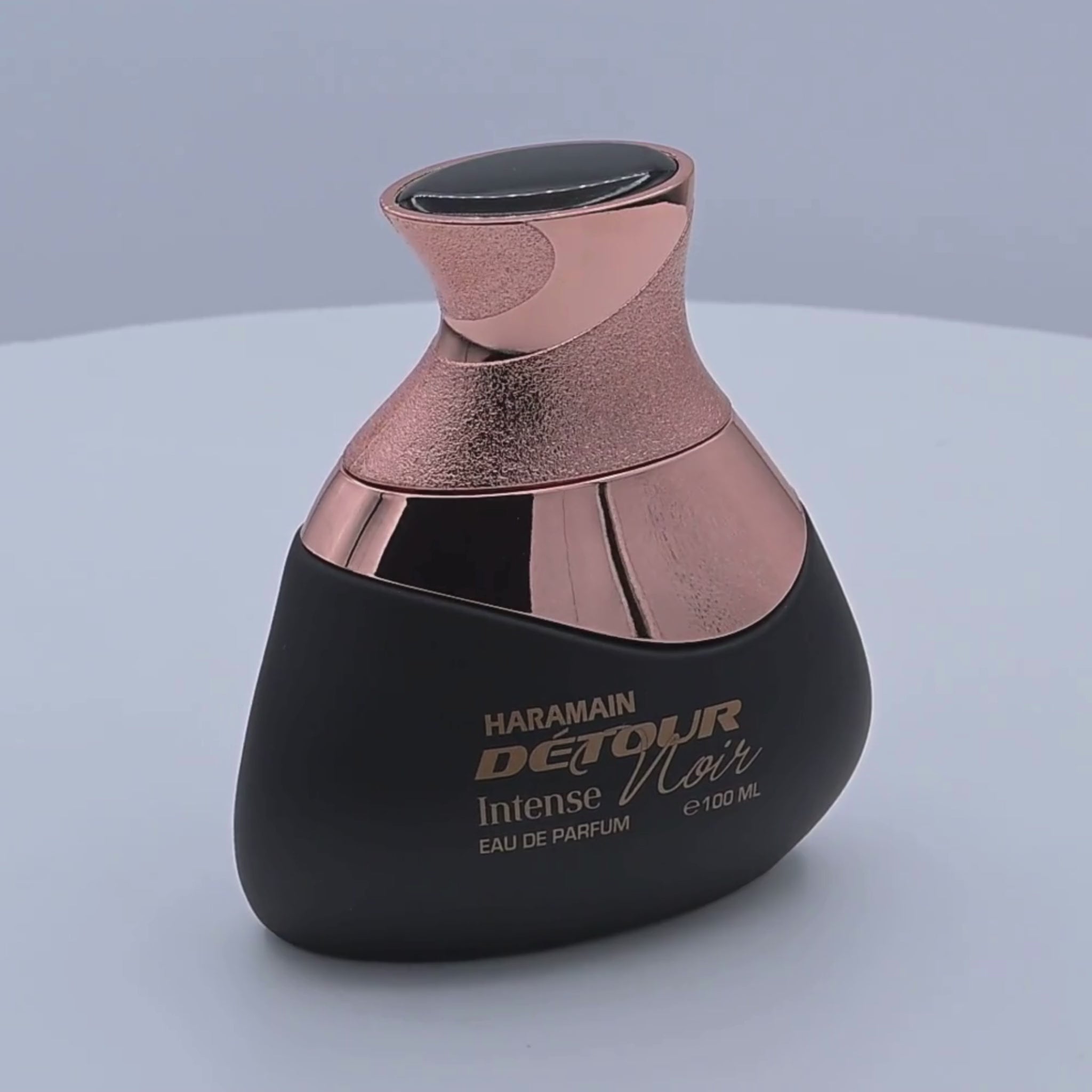 Haramain Detour perfume bottle rotating on a white podium
