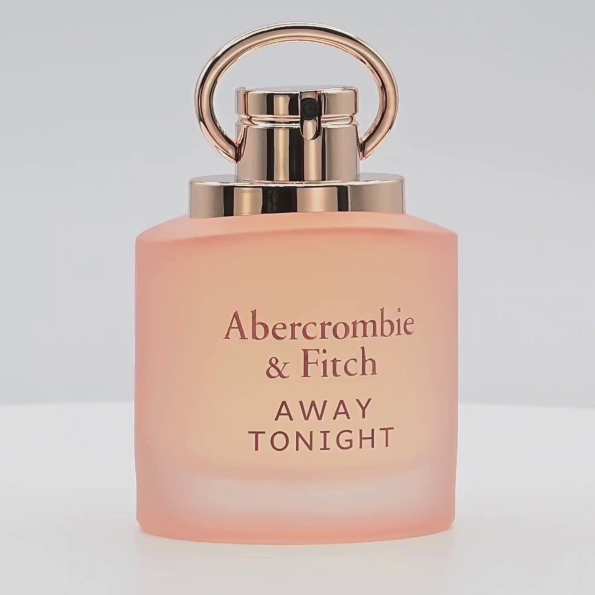 A bottle of Abercrombie & Fitch perfume rotating on a white podium