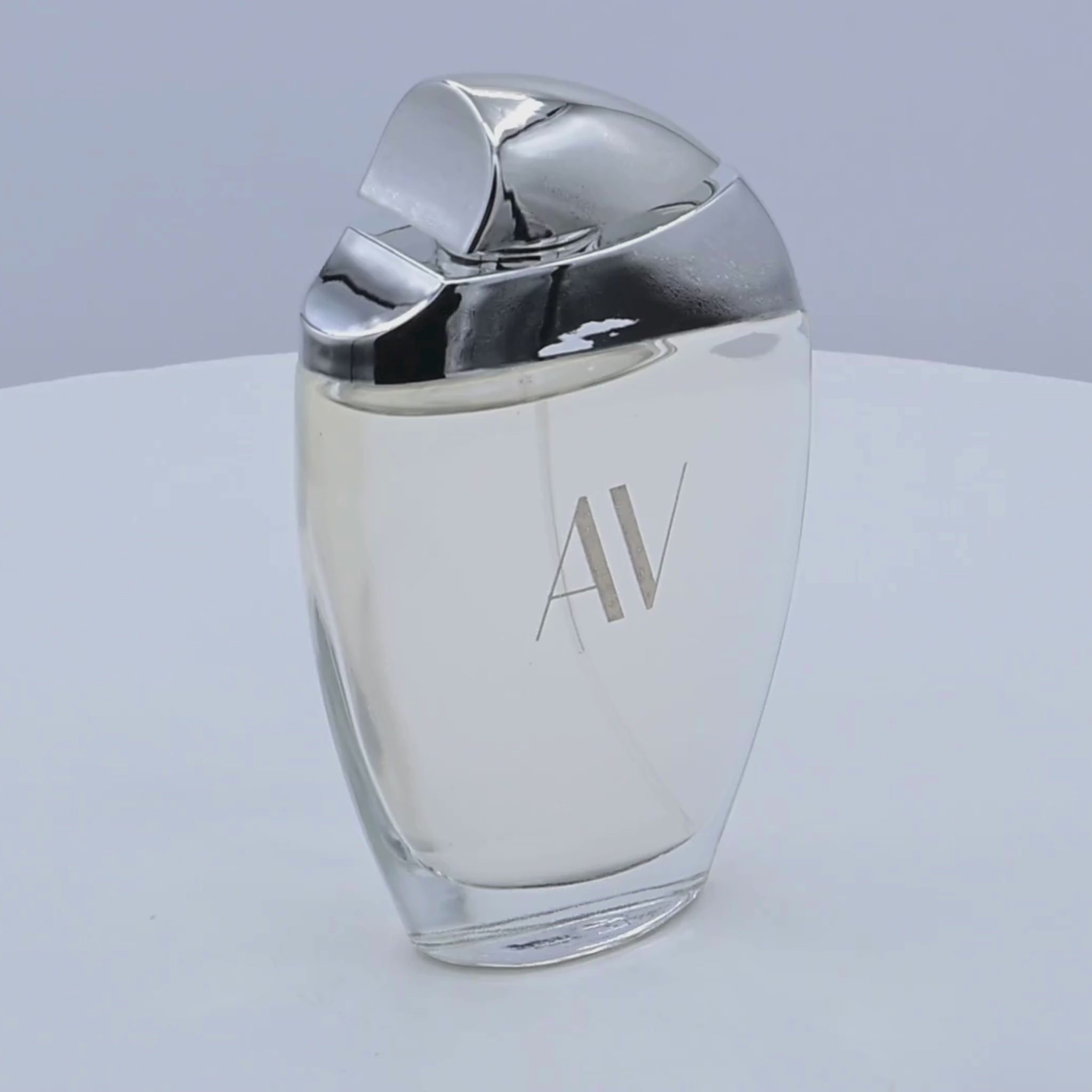 Adrienne Vittadini Eau de Parfum bottle rotating on a white podium