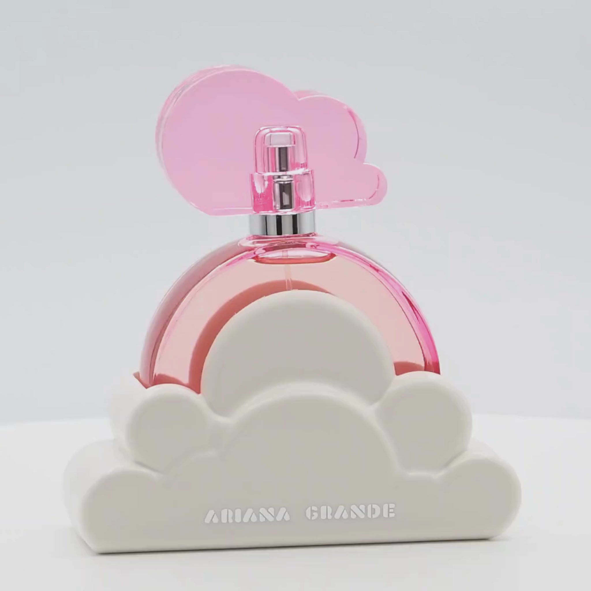 Ariana Grande Cloud Pink perfume bottle rotating on a white podium
