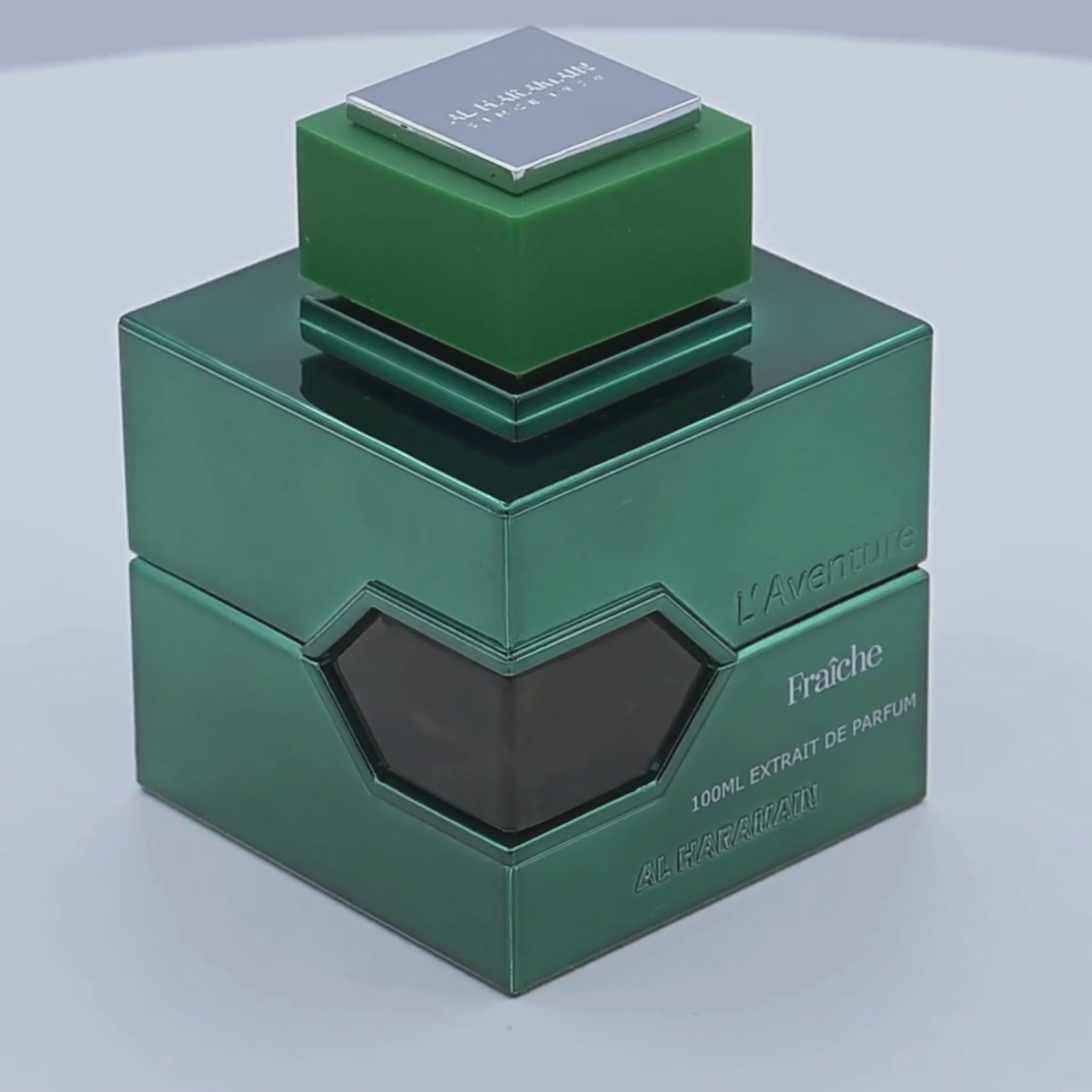 Green Al Haramain perfume bottle rotating on a white podium