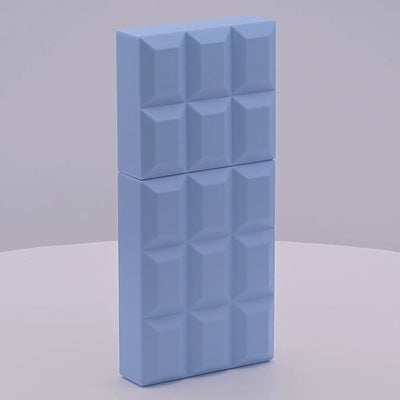 Blue chocolate bar-shaped perfume bottle rotating on a white podium