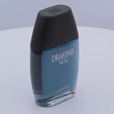 Drakkar Bleu perfume bottle rotating on a white podium