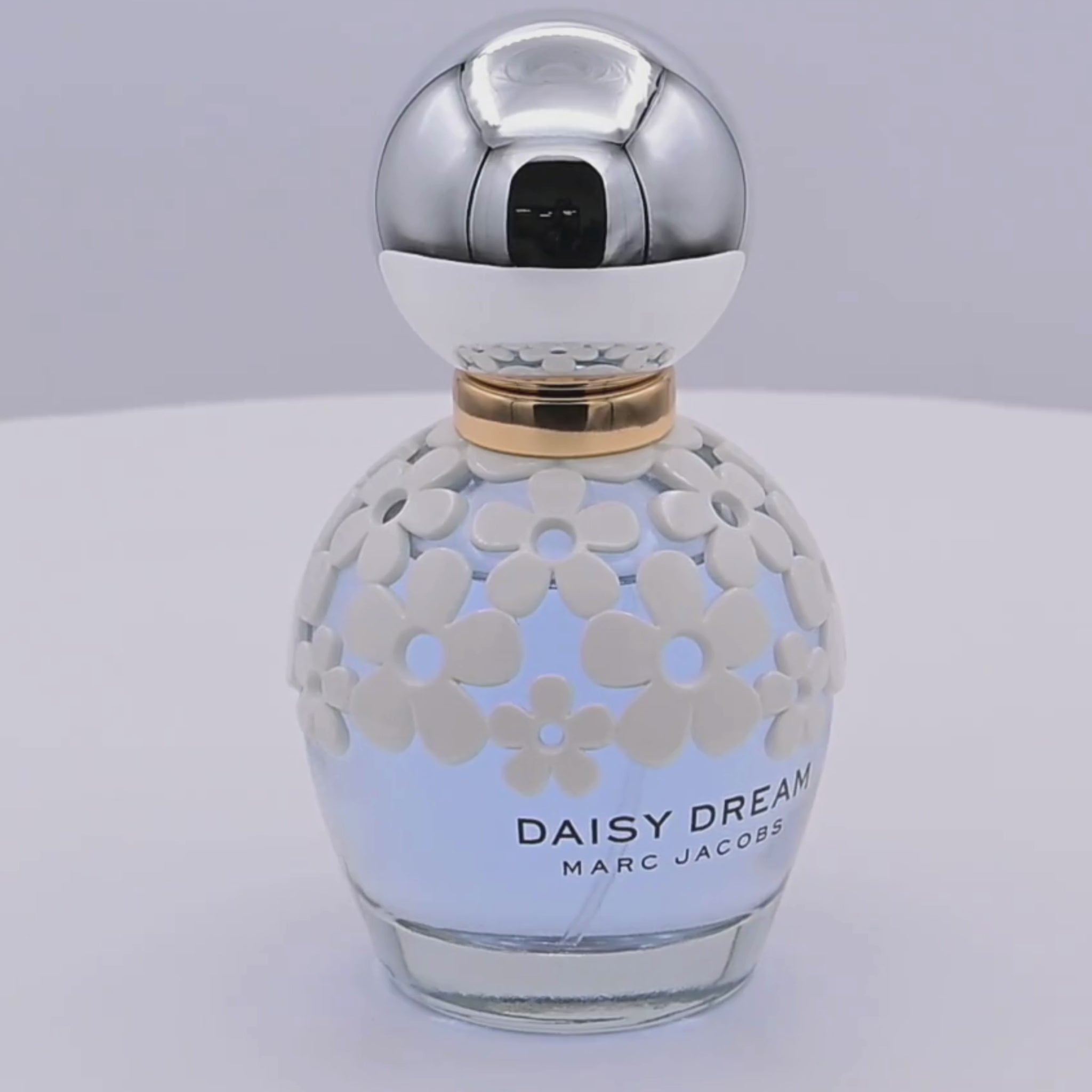 Perfume bottle with floral design rotating on a white podium