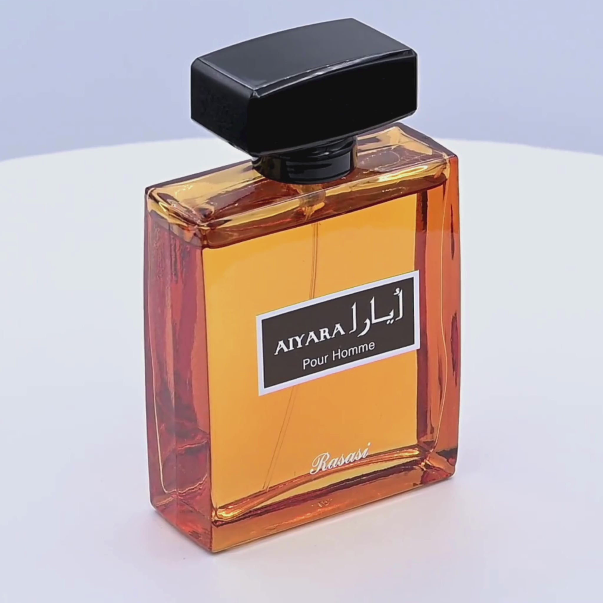 Perfume bottle labeled 'Aiyara Pour Homme' by Rasasi rotating on a white podium